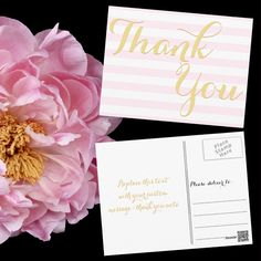 a pink flower and some cards on a black background with the words thank you written in gold