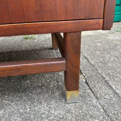 a close up of a wooden bench on the ground