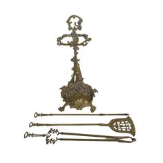 an old fashioned metal object with two spoons and a cross on the back side