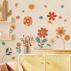 a wall with flowers and cactus decals on it's side, next to a dresser