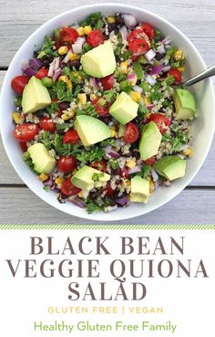 black bean veggie quinoa salad with avocado and tomatoes in a white bowl