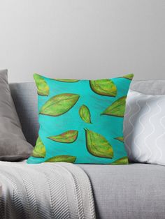 a blue and green throw pillow with leaves on it