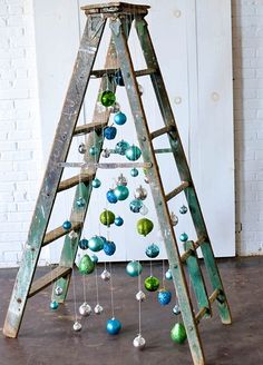 an old ladder with ornaments hanging from it