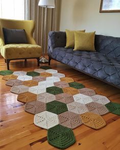 a living room with a couch, chair and crocheted rug