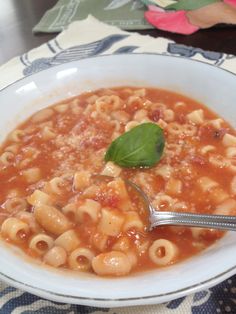 a white bowl filled with macaroni and cheese soup on top of a table