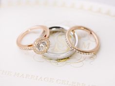 two wedding rings sitting on top of an open marriage book with the words, the marriage celebration of mr and mrs