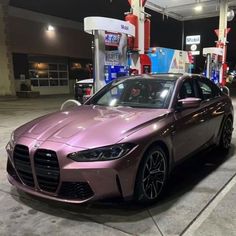 a purple car parked in front of a gas station