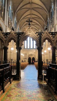 the inside of an old church with stained glass windows and pews on either side