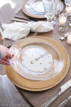 the table is set with plates, silverware and candles for an elegant dinner party