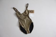 "Vintage 1970's-1980's iconic black and gold one piece swimsuit by Bill Blass with a wired bra top, high cut hip, and open scoop back. Unworn/deadstock with original tags still attached. Fits Like: XS/Small Circa 1970s Fabrication: nylon spandex blend Condition: excellent! 34\" bust" Gold Summer Evening Swimwear, Gold Evening Swimwear For Summer, Chic Lined Swimwear For Party, Party Swimwear With Underwire And Lining, Chic Party Swimwear Lined, Gold Fitted Swimwear With Lined Body, Fitted Gold Swimwear With Lined Body, Gold Swimwear With Lined Body For Summer, Retro Fitted Party Swimwear