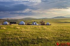 an open field with some buildings in the distance