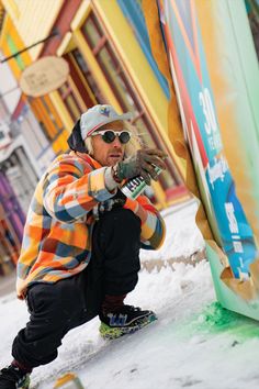 a man kneeling down in the snow next to a pole