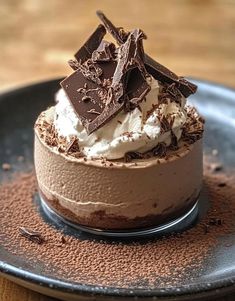 a chocolate dessert with whipped cream and chocolate pieces on top