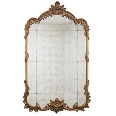 an ornate mirror with gold trimmings on the edges and a carved frame, against a white background