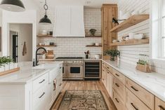 a kitchen with wooden cabinets and white counter tops, an area rug on the floor