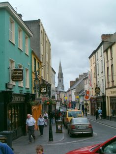 people are walking down the street in an old town