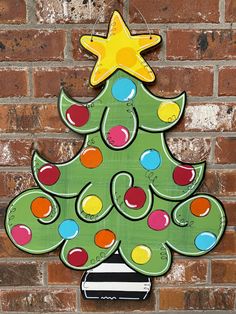 a wooden christmas tree hanging on a brick wall