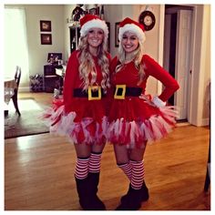 two women dressed as santa clause standing next to each other