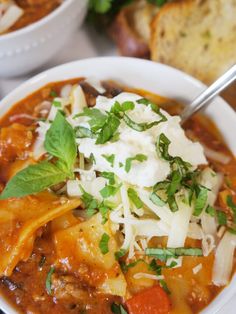 two bowls of soup with bread and parmesan cheese on the side, ready to be eaten