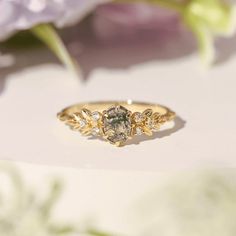 a close up of a ring with flowers in the background