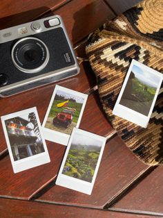 an old camera and some polaroid pictures on a wooden table next to a rug