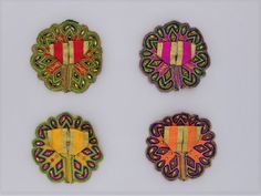 four pieces of embroidered fabric with designs on them