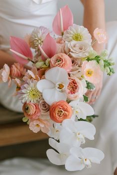 a bride holding a bouquet of flowers in her hands