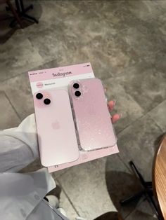 someone holding up two pink iphones in their hands, one is empty and the other has