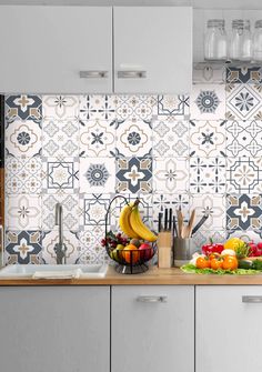 a kitchen counter with fruits and vegetables on it, next to a wallpapered backsplash