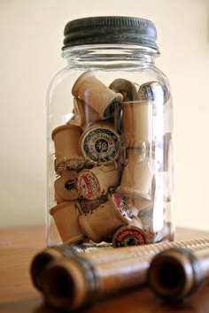 a glass jar filled with lots of different types of buttons