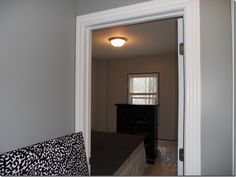 a bed sitting in the middle of a bedroom next to a doorway with a light on