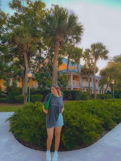 a woman standing in front of some palm trees