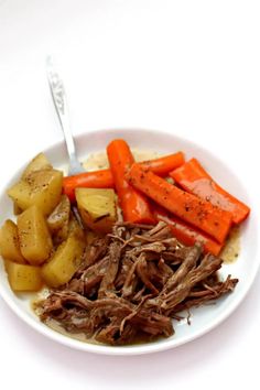 a white plate topped with meat, potatoes and carrots