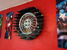 the wall is painted red and has various pictures on it, including an iron man wheel