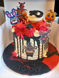 a decorated birthday cake in the shape of a hat with cartoon characters on it,