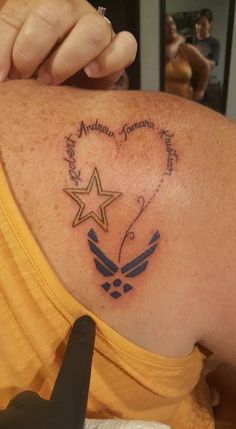 the back of a woman's shoulder with an eagle and star tattoo on it