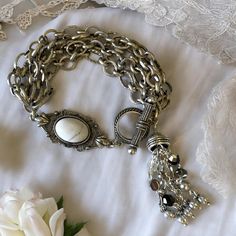 * Bracelet Toggle is old silver finish pewter cast in the USA by the 1928 Jewelry Co. * Ornate toggle from the 1928 Jewelry Company * Tassel with beaded chain * Silver plated chains of various widths and styles * 9" length, including toggle, to fit 7 1/2" to 8 1/4" wrists * Signed * All pieces ship in a gift box, ready for gift giving! Please follow all care instructions included with all Bohemian Happiness jewelry to ensure your jewelry always looks its best!  Bohemian Happiness Collectible Jewelry is one-of-a-kind due to the nature of being handmade. No two pieces are exactly alike! All jewelry in made in the USA with high quality components sourced from the best manufacturers here and around the world. All items are made to the strictest quality standards and we stand behind everything Antique Silver Metal Jewelry With Lobster Clasp, Silver Vintage Bracelets With Antique Finish, Adjustable Antique Silver Jewelry, Antique Silver Metal Jewelry, Bohemian Antique Silver Jewelry With Vintage Charm, Antique Silver Jewelry With Vintage Charm, Silver Metal Bracelets With Antique Finish, Silver Metal Bracelet With Antique Finish, Silver Metal Bracelets Vintage