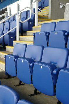 rows of blue seats in an empty stadium