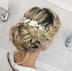 a woman with blonde hair wearing a flowered headpiece in front of a mirror