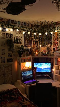 a laptop computer sitting on top of a desk in front of a tv monitor and bookshelf