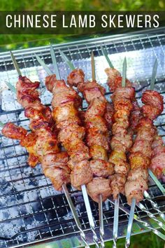 several skewers are being cooked on a grill with the words chinese lamb skewers above them