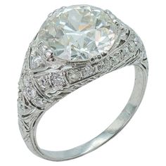 an antique style diamond ring with filigrees on the shoulders and sides, set in