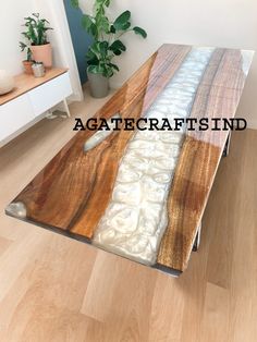 the table is made out of wood and has white paint on it, along with an interesting design