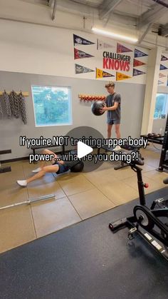 a man is doing exercises in the gym with an exercise ball while another man watches