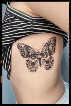 a butterfly tattoo on the side of a woman's ribcage is shown