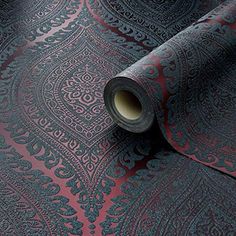 a roll of black and red wallpaper with an intricate design on it's surface