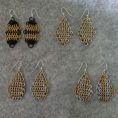 four pairs of earrings are shown on a gray surface, one is gold and the other is black