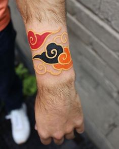 a man's arm with a tattoo on it that has an orange and black design