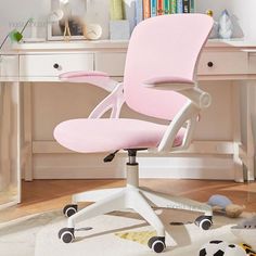 a pink office chair sitting on top of a wooden floor next to a white desk