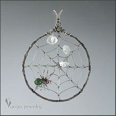 a silver plated wire and glass spider web ornament hanging from a chain